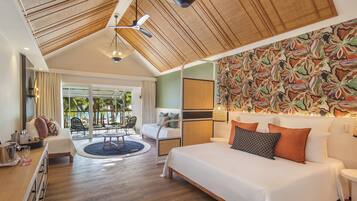 A spacious bedroom with a large bed, a dining area, and a view of the outdoor pool area.