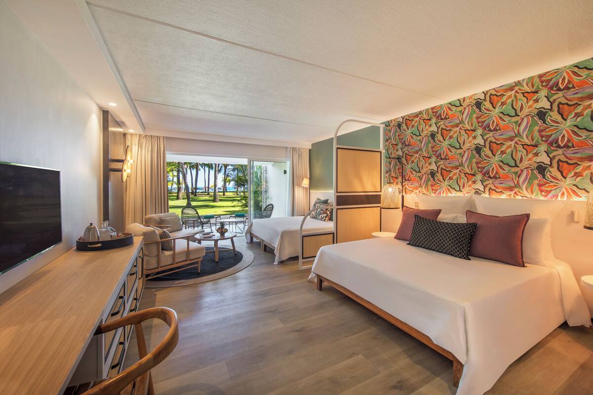 Una habitación de hotel con cama, escritorio, televisión y vistas al exterior.