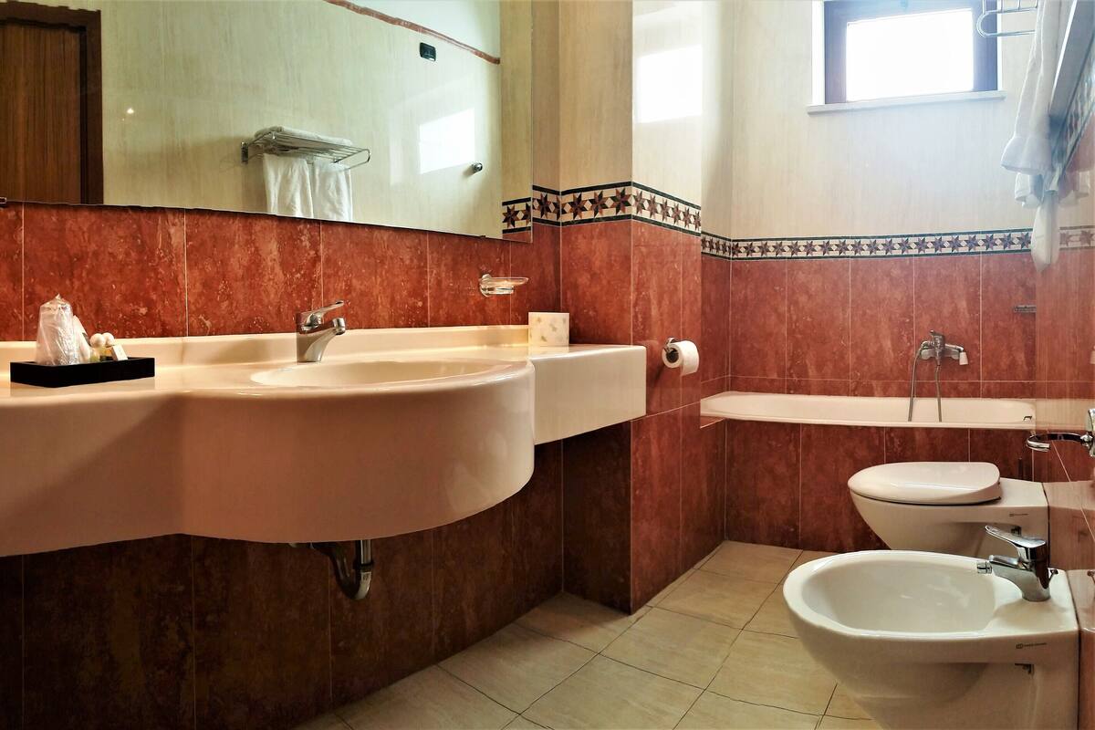 A bathroom with two sinks, a toilet, and a bidet.