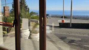 L’entrée d’un hôtel, avec une porte en verre, donnant sur le parking, et une enseigne indiquant le nom de l’hôtel.