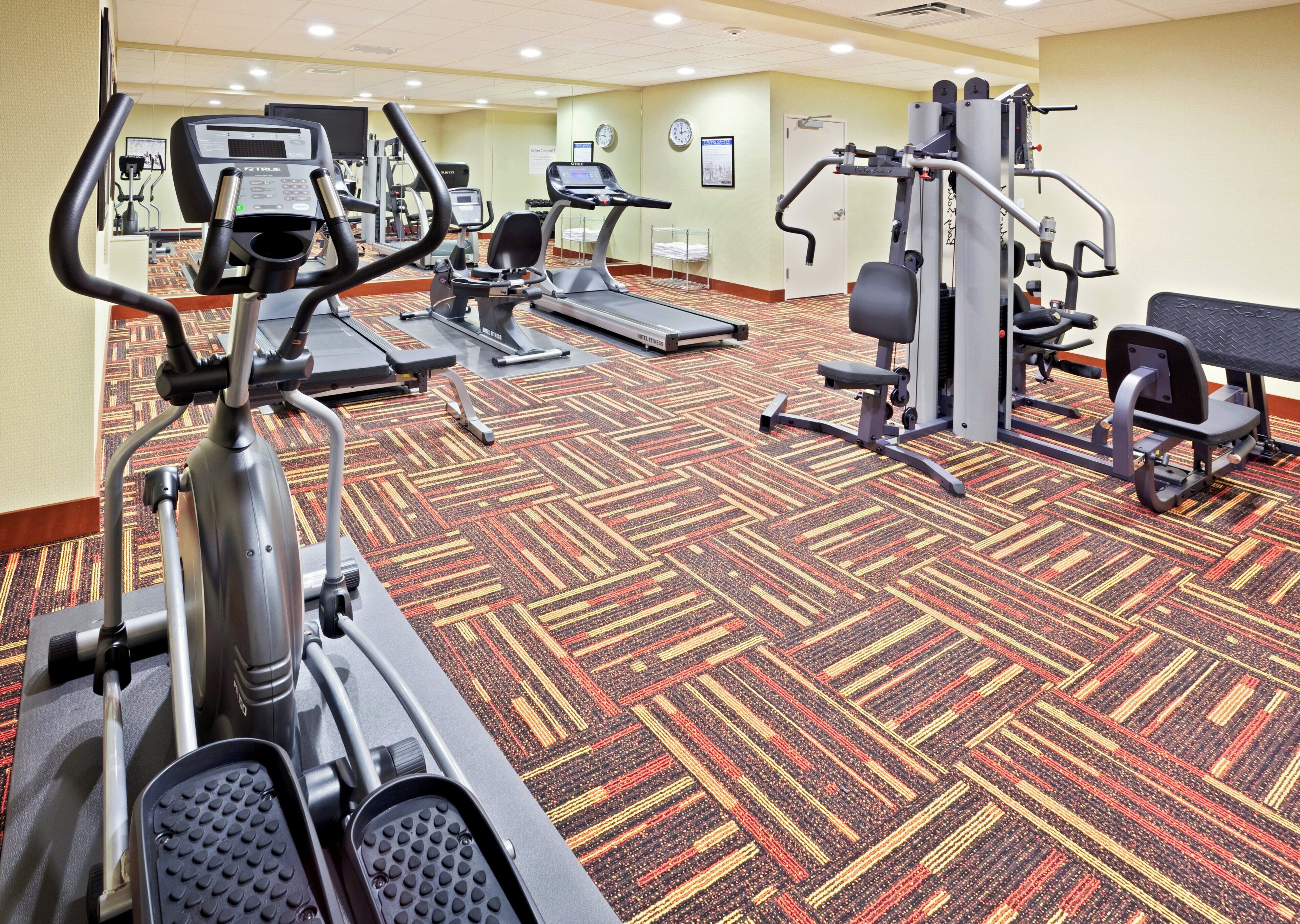 A gym with treadmills, elliptical machines, and weight equipment.