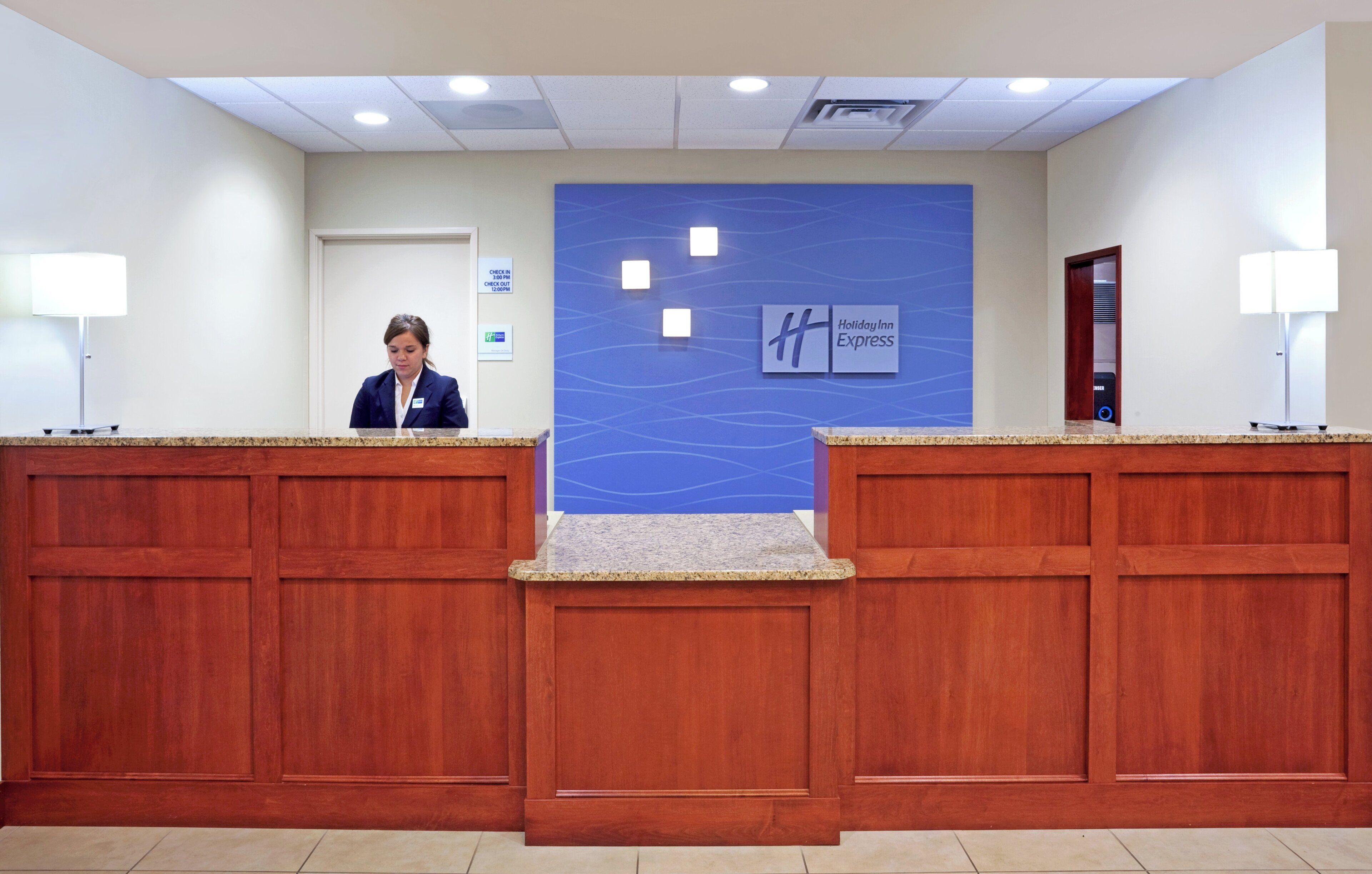 Un mostrador de recepción con una pared azul y el letrero de Holiday Inn Express.
