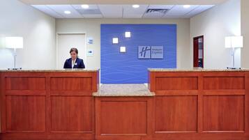 Un mostrador de recepción con una pared azul y el letrero de Holiday Inn Express.