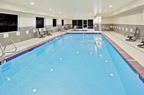 A large indoor swimming pool with multiple lounge chairs and a tiled deck area. - Holiday Inn Express Chehalis-Centralia by IHG (Chehalis)