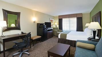 Una habitación de hotel con cama, escritorio, silla, televisor y sofá.