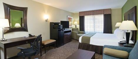A hotel room with a bed, a desk, a chair, a television, and a sofa.