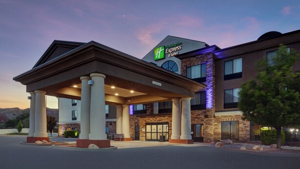 A Holiday Inn Express hotel with a covered entrance, stone facade, and illuminated signage.