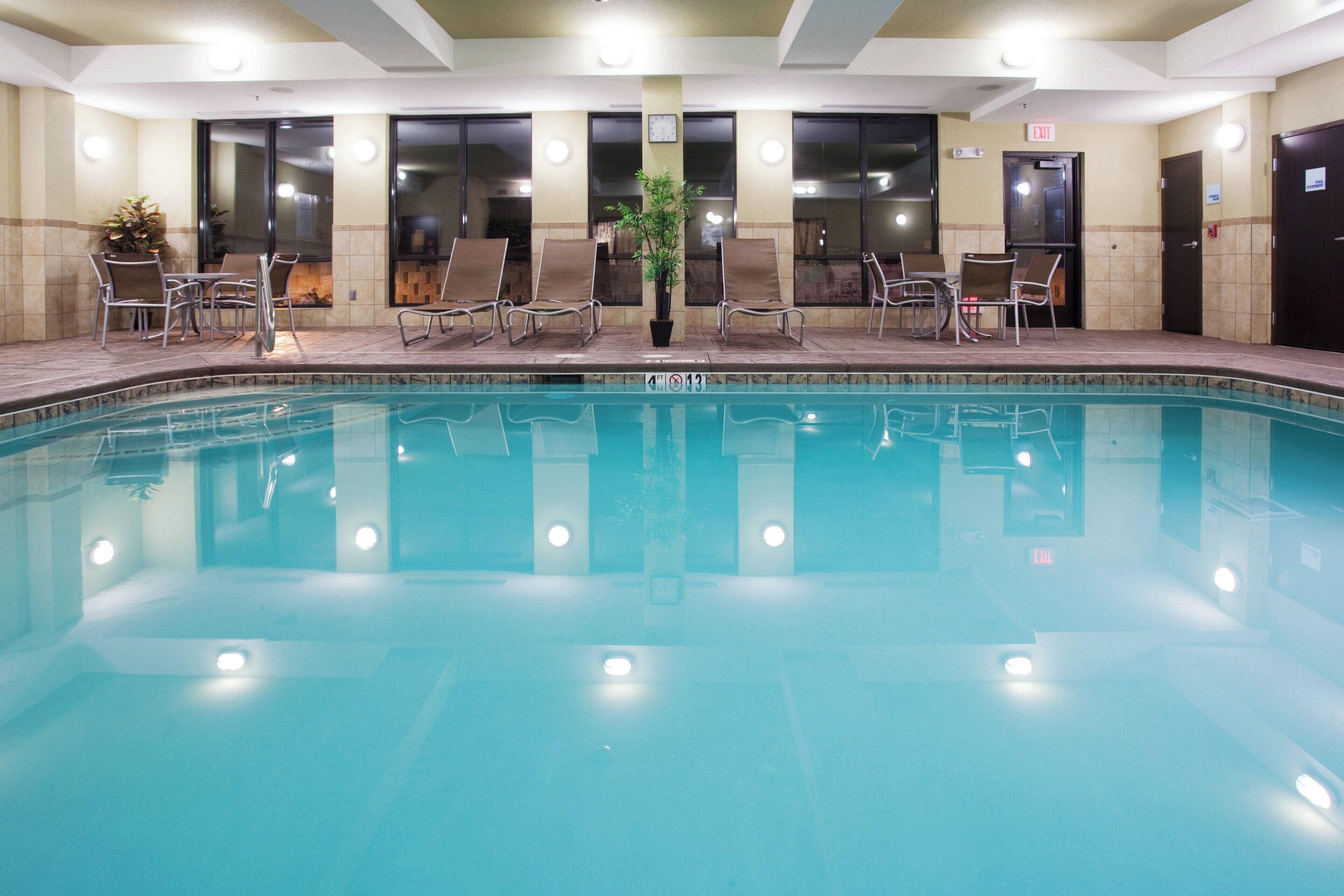 A swimming pool with lounge chairs and a potted plant.