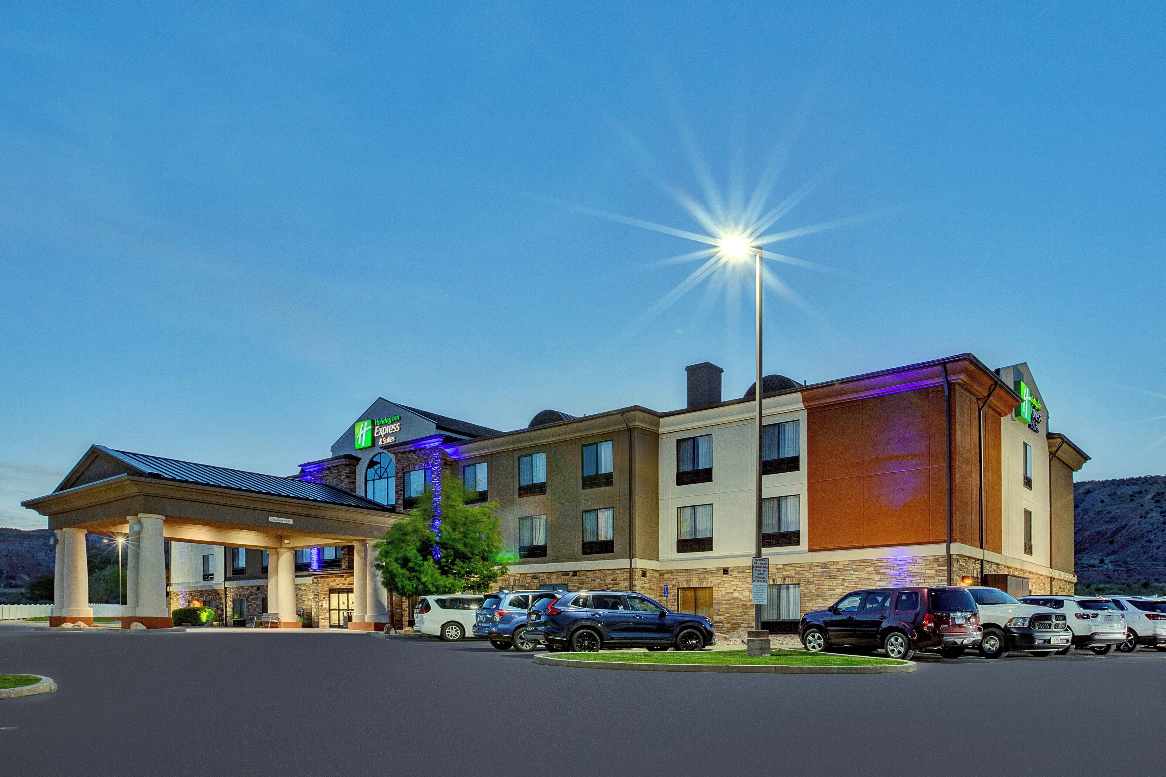 Un hotel Holiday Inn Express con un estacionamiento y varios autos estacionados al frente.