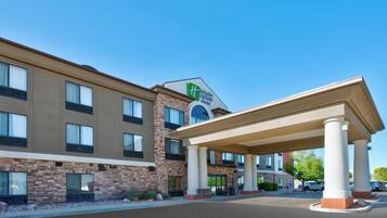 A hotel with a brick facade, a covered entrance, and a sign indicating it is a Holiday Inn Express.