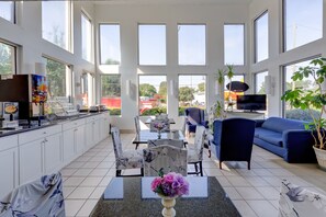 A spacious living area with a kitchen, dining table, and seating.