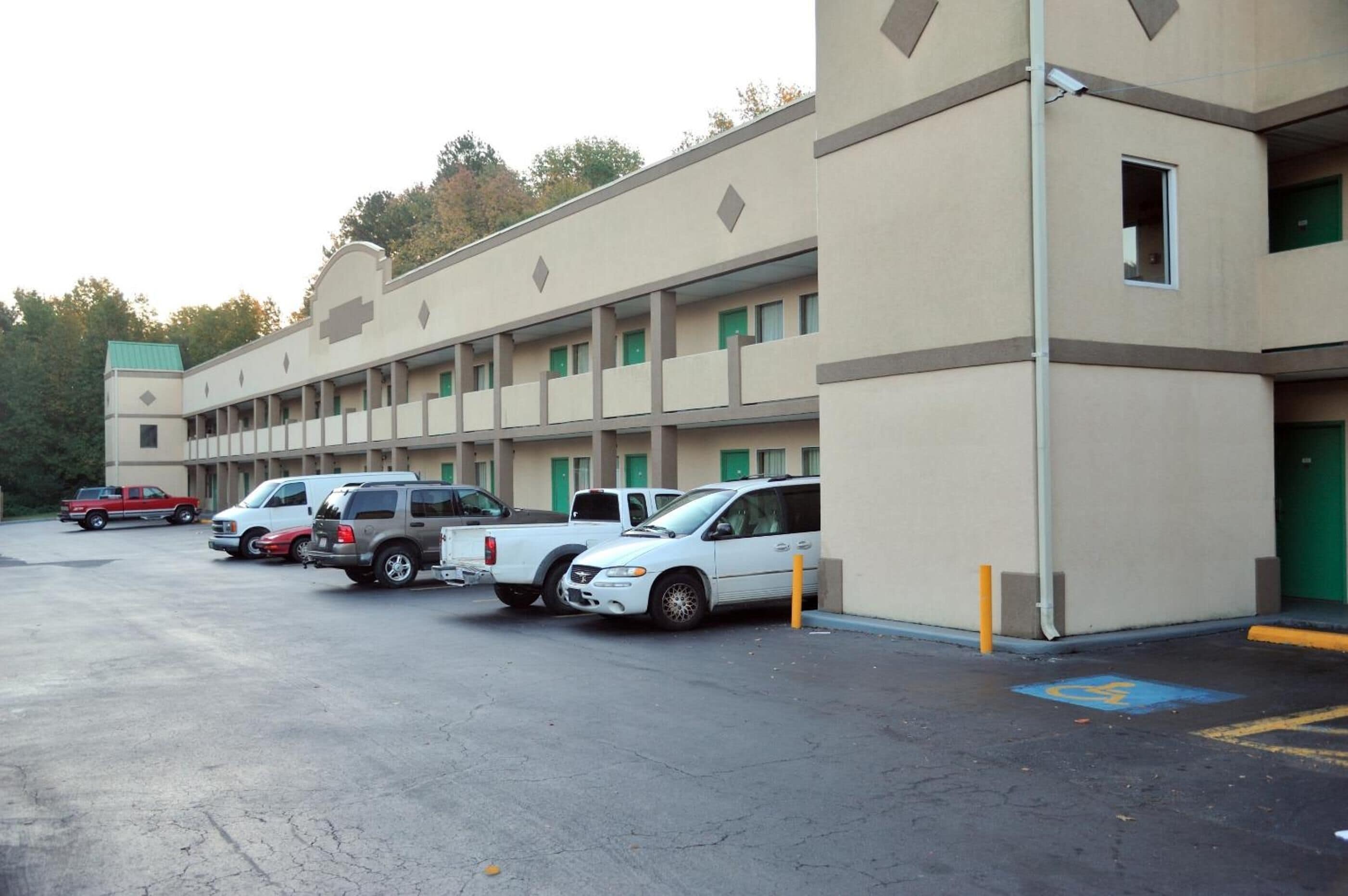 A multi-story parking garage with several cars parked in front.