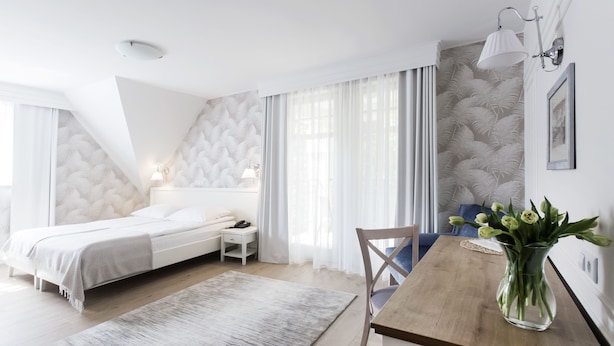 A modern bedroom with a bed, bedside table, lamp, and a view of the outdoors. - Hotel Villa Baltica (Sopot)