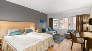 Una habitación de hotel con una cama grande, un sofá, un escritorio y una silla.