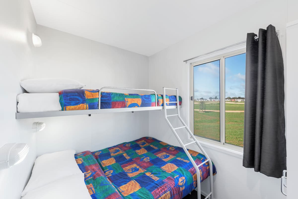 A bunk bed room with a window and a view of the outdoors.