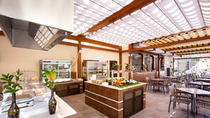 A spacious restaurant with a central island, multiple seating areas, and a modern ceiling design. - GF Isabel (Adeje)