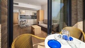 A modern hotel room with a balcony, a dining area, and a kitchen. - Almirall Apartaments (Lloret de Mar)