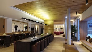 Una cocina moderna con una isla grande, taburetes de bar y una columna central.