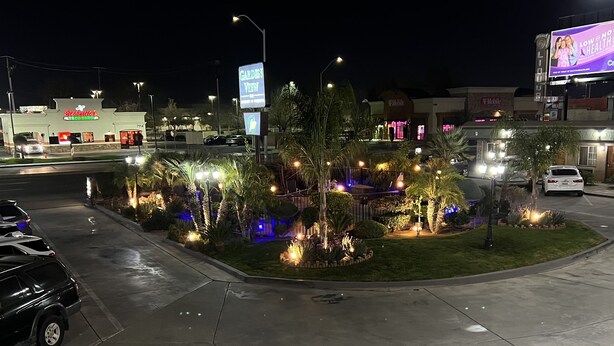 A well-lit intersection with a Taco Bell restaurant, a garden view sign, and a T-Mobile store. - Garden View Inn (Fresno)