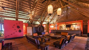 A rustic interior with wooden furniture, a bar area, and a large wheel structure. - Decameron Panaca All Inclusive (Quimbaya)