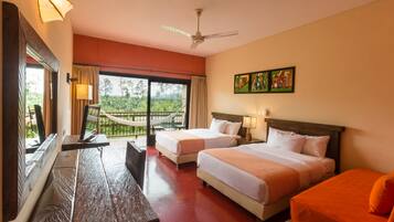 A hotel room with two beds, a wooden bench, a hammock, and a balcony with a view of greenery.