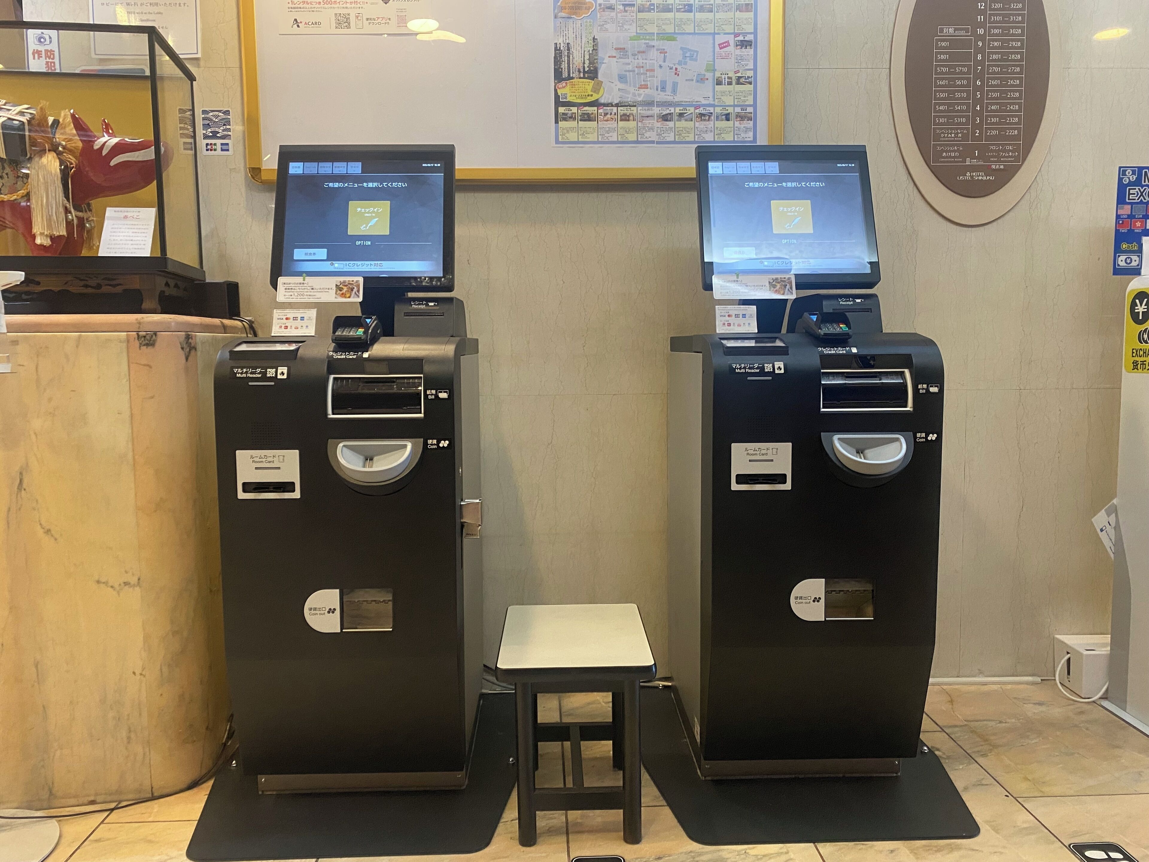 Two self-service kiosks with card readers and a small table in between.
