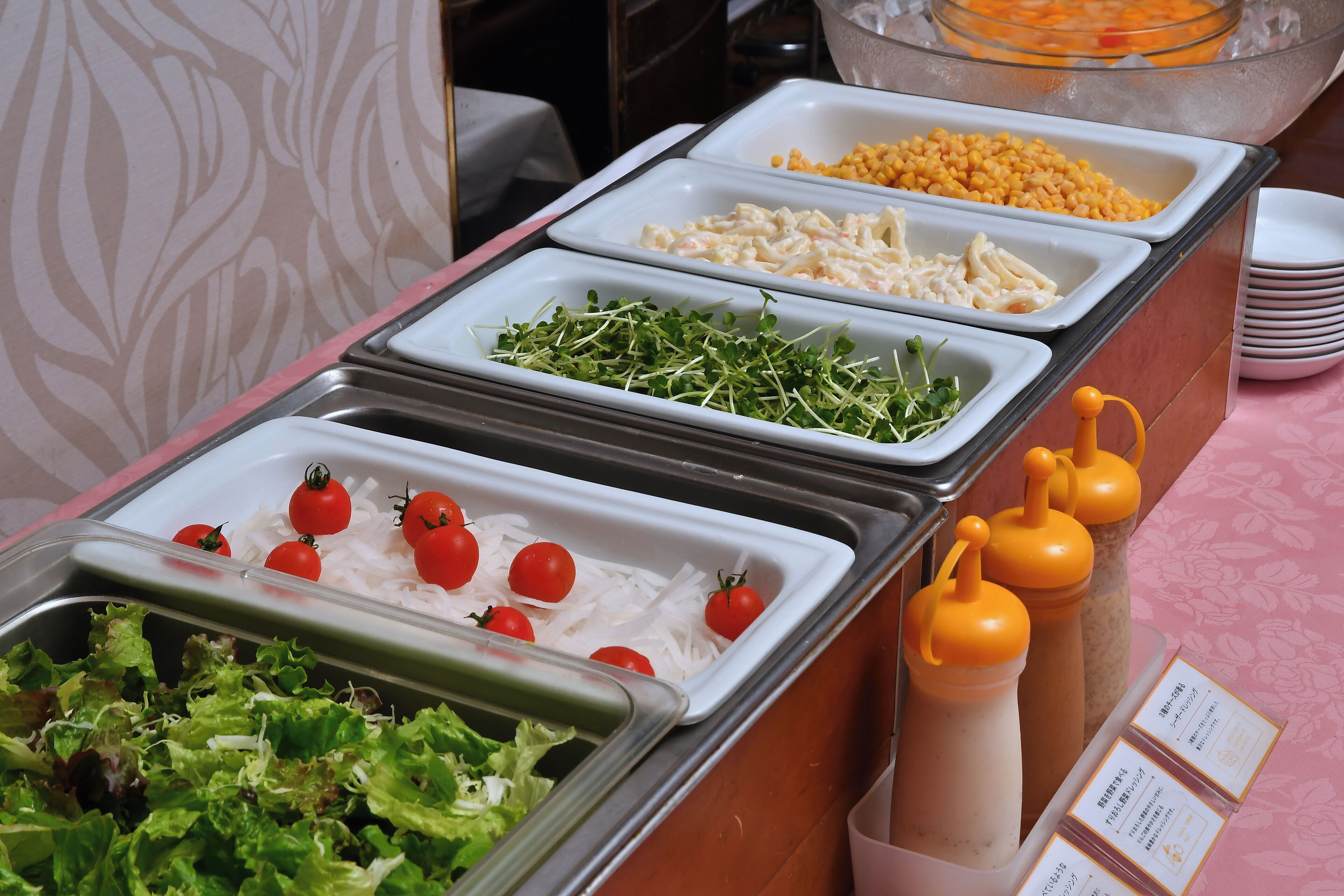 Un buffet proposant une variété de plats, notamment des salades, des céréales et des légumes.