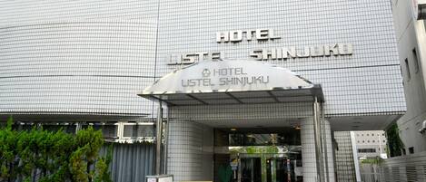 A hotel entrance with a modern facade, a visible entrance, and a sign indicating the hotel name.