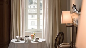 A dining table set with tea cups, a teapot, a vase with flowers, and a pitcher of orange juice. - Grand Hotel della Posta, WorldHotels Distinctive (Sondrio)