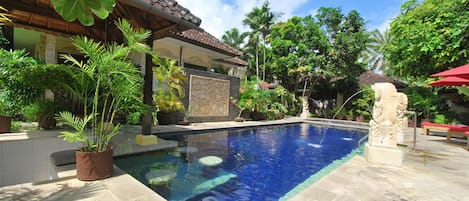 Alberca al aire libre, sombrillas en la alberca y camastros