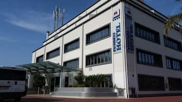 Un hotel moderno para negocios con entrada de vidrio, múltiples ventanas y un letrero que indica que es un hotel de negocios.