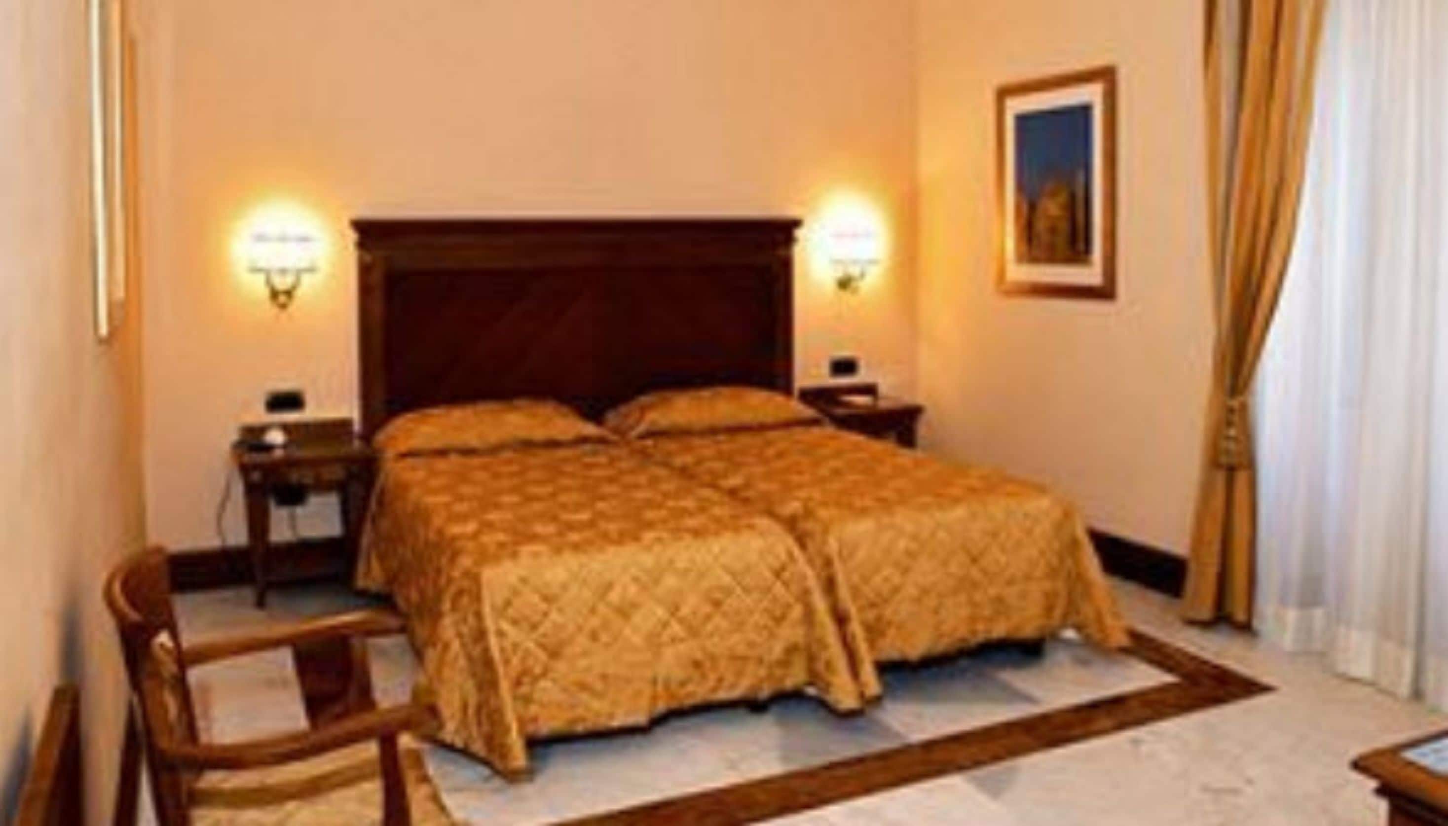 Un lit double avec une tête de lit en bois, deux tables de chevet, une commode, une chaise et un tableau accroché au mur.