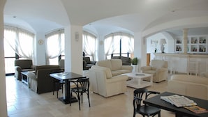 Amplia sala de estar con una mesa de comedor, varios sofás y una cocina con barra.
