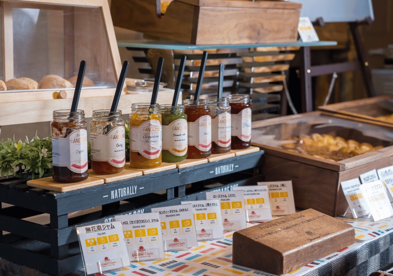 A display of various jams and jellies with labels and price tags.