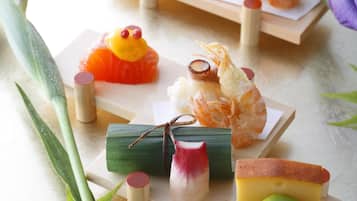 A variety of sushi and sashimi on wooden trays, accompanied by small condiments and decorative elements.