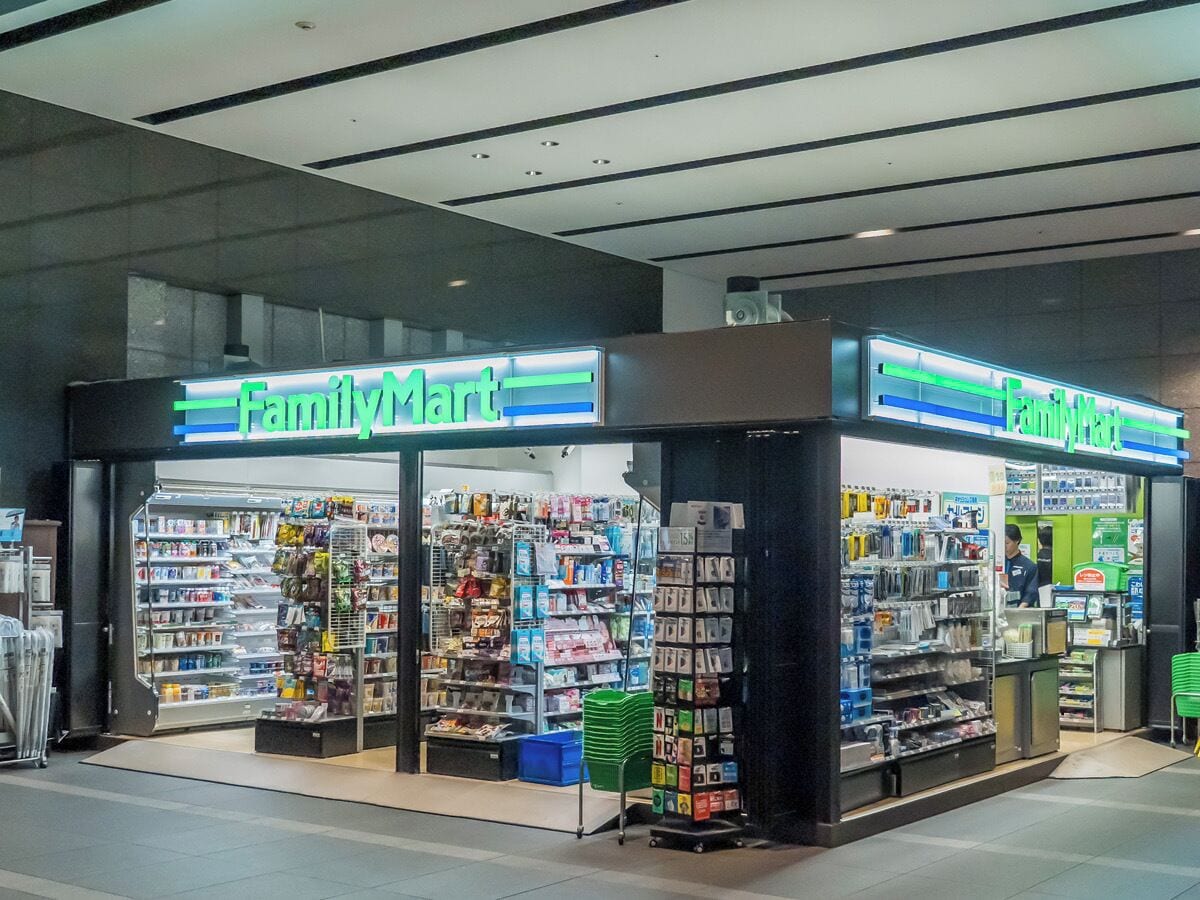 Una tienda FamilyMart con estantes llenos de aperitivos, bebidas y artículos para el hogar.