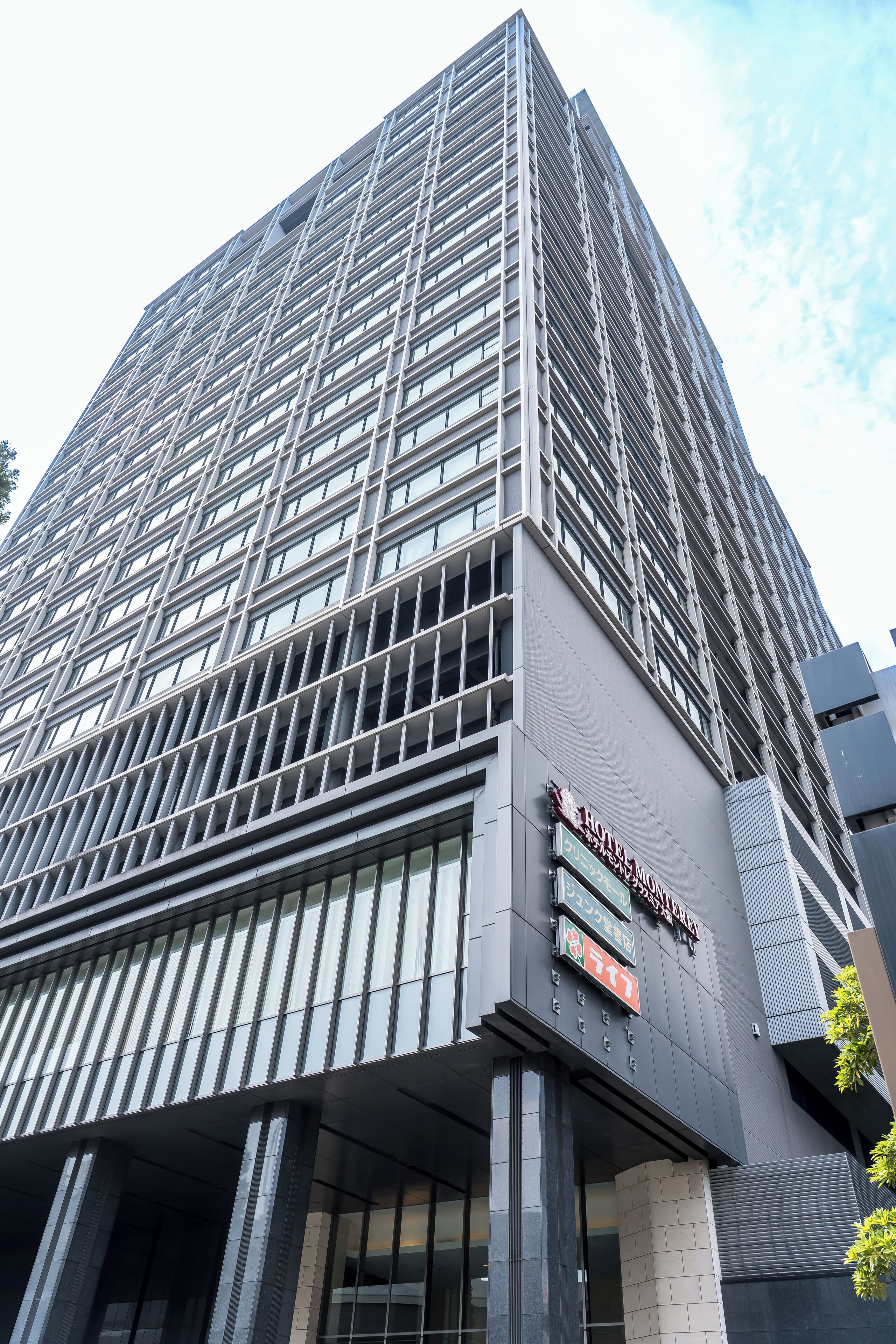 A modern high-rise building with a prominent sign for the "Hotel New York" and a visible entrance.
