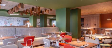 A modern restaurant with booths and tables, a counter, and a ceiling with wooden slats.