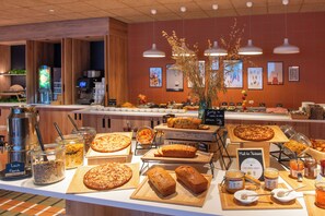 Un buffet proposant une variété de plats et un coin café.