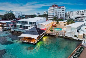 A waterfront hotel with a pool, multiple buildings, and clear water. - Decameron Los Delfines All Inclusive (San Andrés)