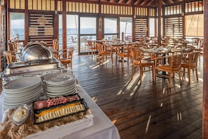 A restaurant with wooden furniture and a buffet setup. - Decameron Los Delfines All Inclusive (San Andrés)