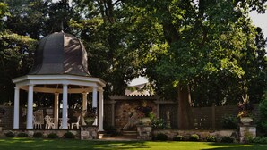 A gazebo with a dome roof, surrounded by a stone wall and lush greenery. - The Inn & Spa at Intercourse Village (Gordonville)