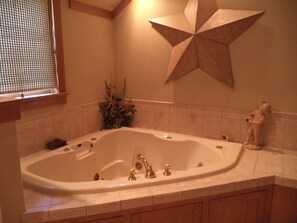 A bathroom with a freestanding bathtub, a decorative star on the wall, and a plant in the corner.