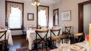 A dining room with four tables, each set with white tablecloths, wooden chairs, and glassware. - The Inn & Spa at Intercourse Village (Gordonville)