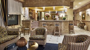 A luxurious living room with wicker furniture, a bar area, and a large vase.