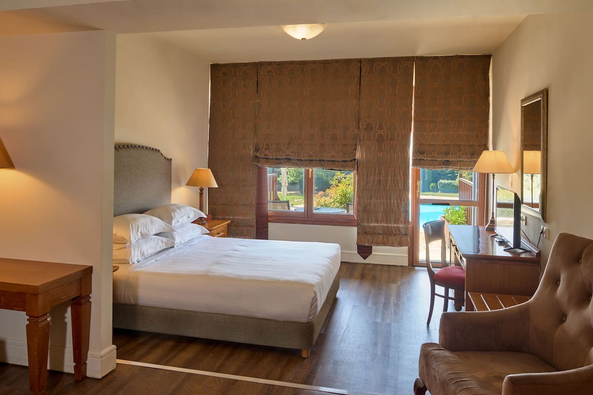 junior suite, terrace, pool view | minibar, in-room safe, desk, blackout curtains