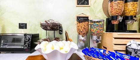 A buffet setup with various food items, including hard-boiled eggs, cereal, and pastries.