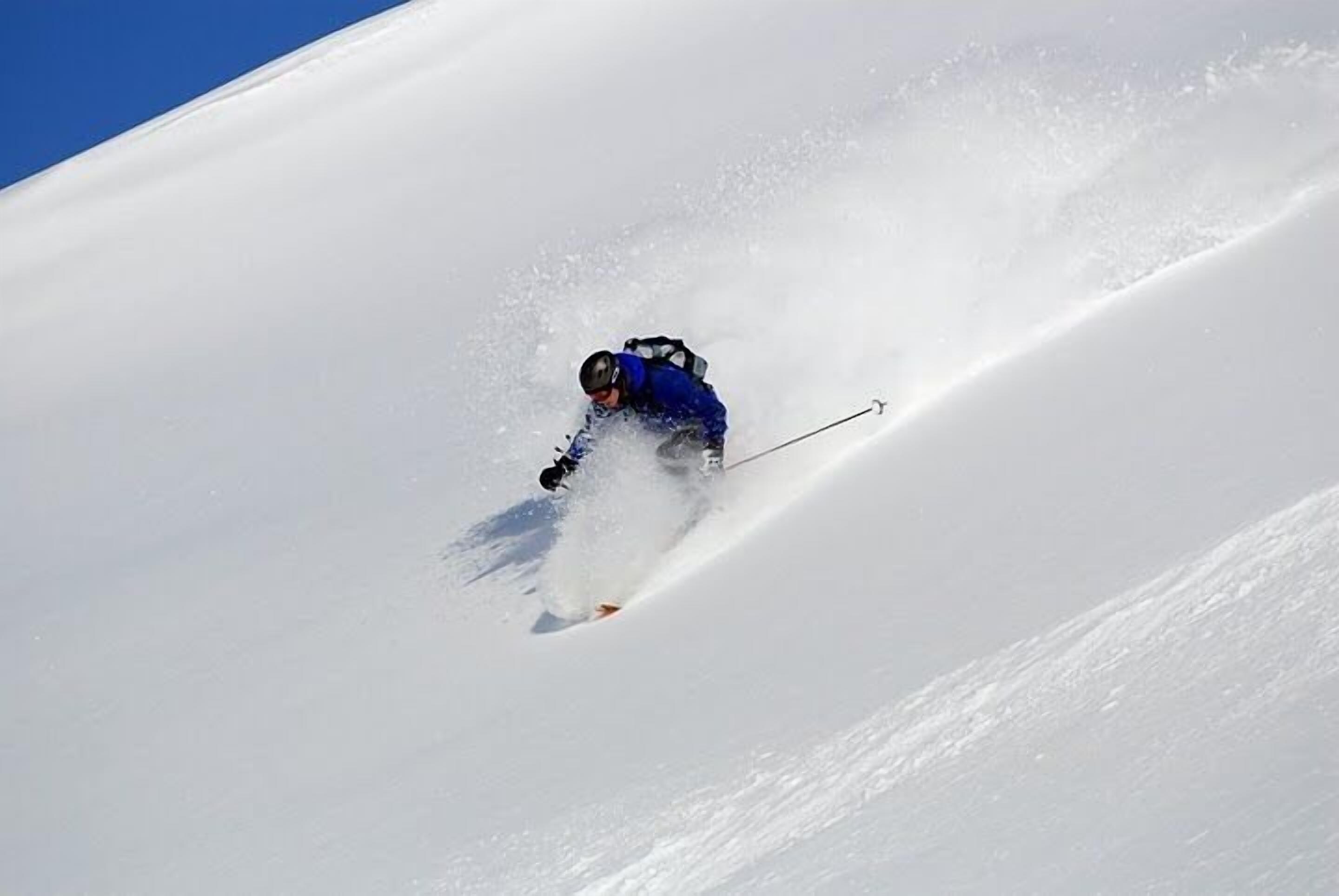 A skier in motion on a snowy slope.