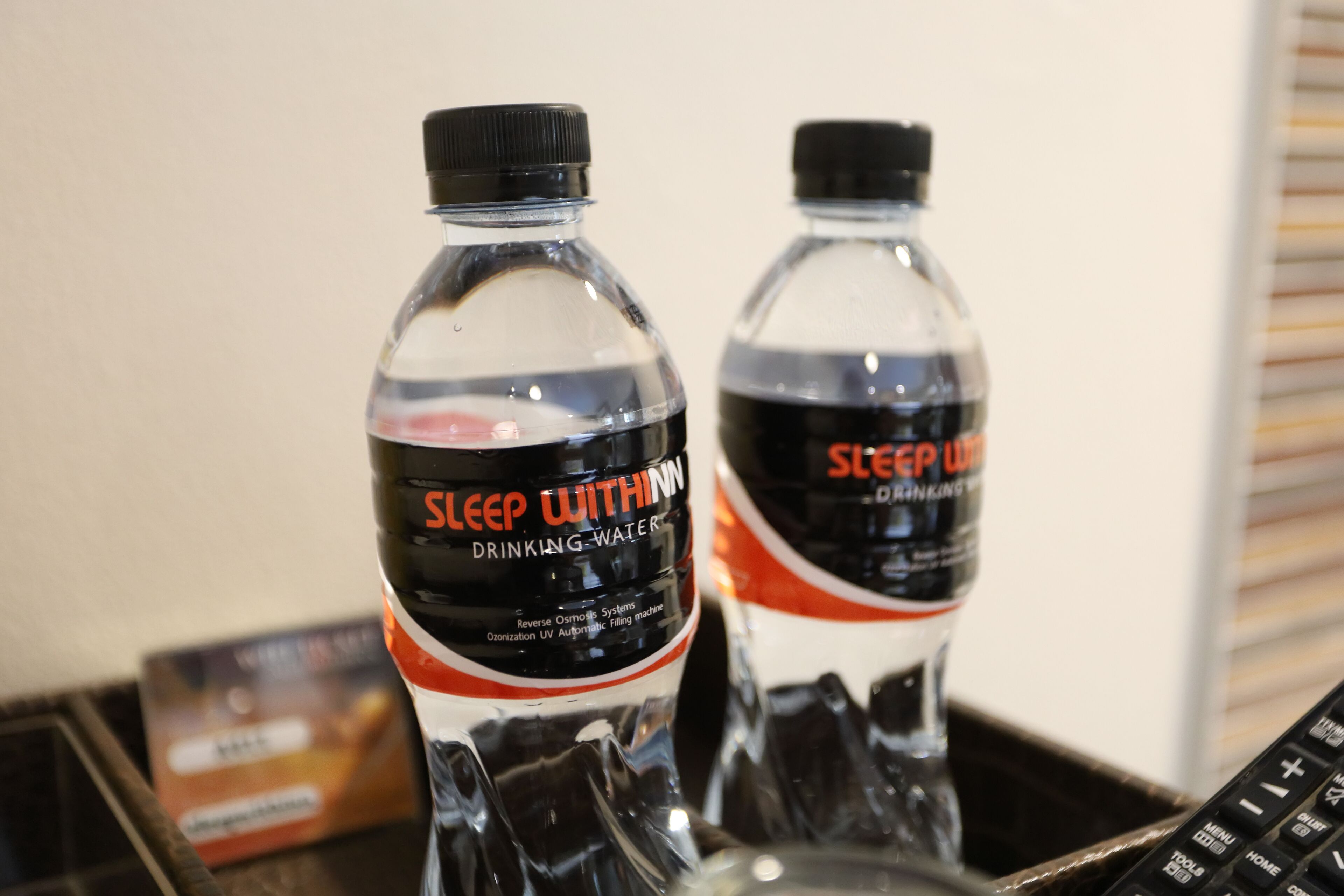 Two bottles of Sleep Within drinking water with a black cap and a label that includes the text "DRINKING WATER" and "Reverse Osmosis System."