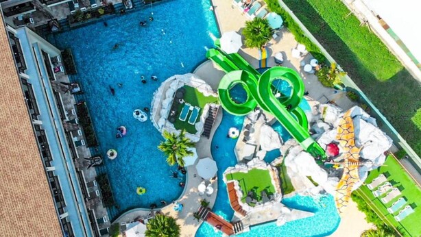 An aerial view of a resort with multiple swimming pools, including a large central pool and smaller pools connected by slides. - Ananta Burin Resort (Krabi)